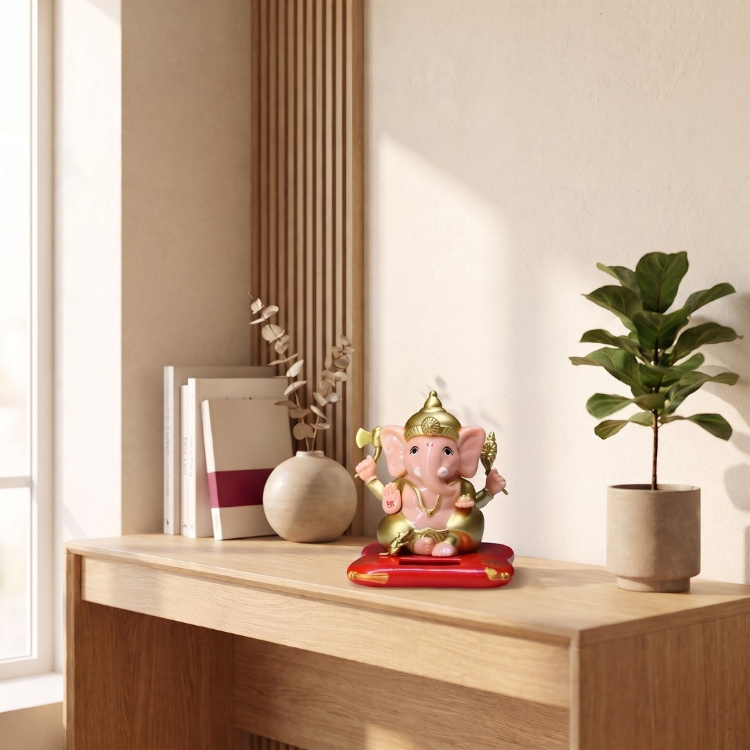 Solar Bal Ganesh Idol in pink and gold finish on a wooden console table