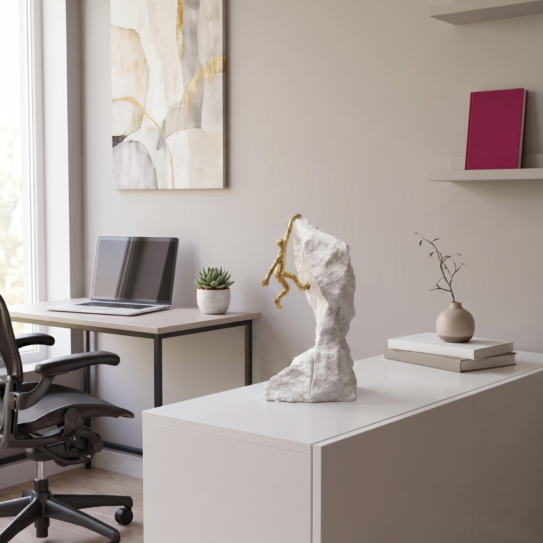 Golden Mountain Climber Figure Sculpture styled on a console table in a modern home office